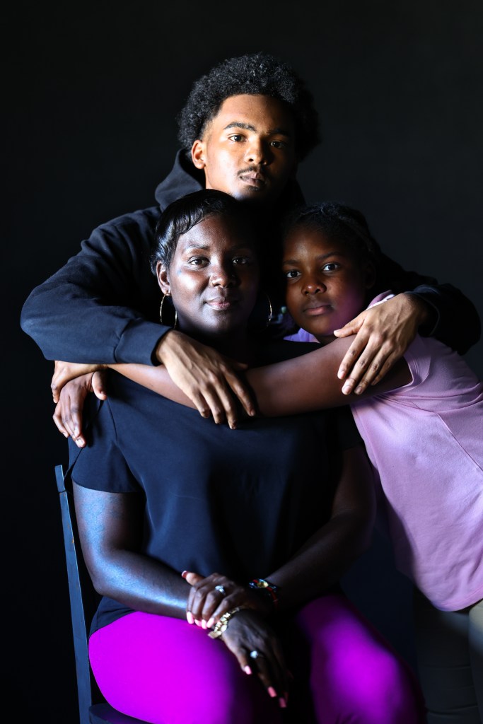 A seated woman poses with two children