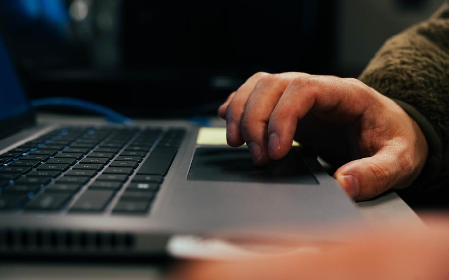 A hand on a touchpad on a computer keyboard.