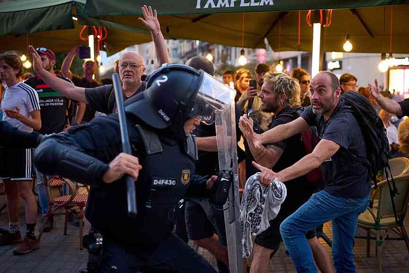 Police officers clash with protesters during a pro-Palestinian rally in solidarity with the Global Sumud Flotilla after ships were intercepted by the Israeli navy, in Barcelona, Spain, Saturday, Oct. 4, 2025. (AP Photo/Emilio Morenatti)