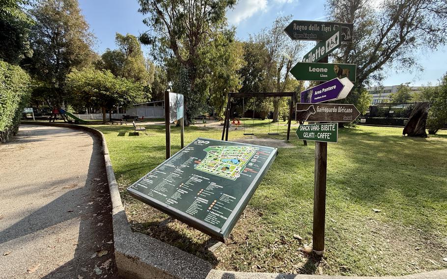 The entrance to Zoo Napoli (Naples Zoo) with a large green sign displaying the zoo’s logo and promotional posters. 