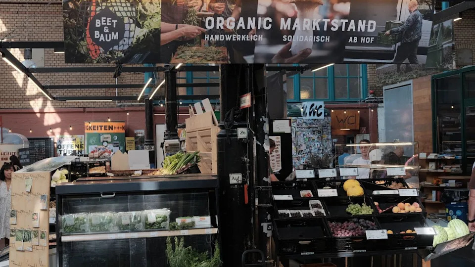 Berlin, Germany - August 9th, 2025: Bustling Markthalle Neun in Berlin’s Kreuzberg district, showcasing vibrant market stalls, artisanal food, and a lively atmosphere in a historic indoor setting.