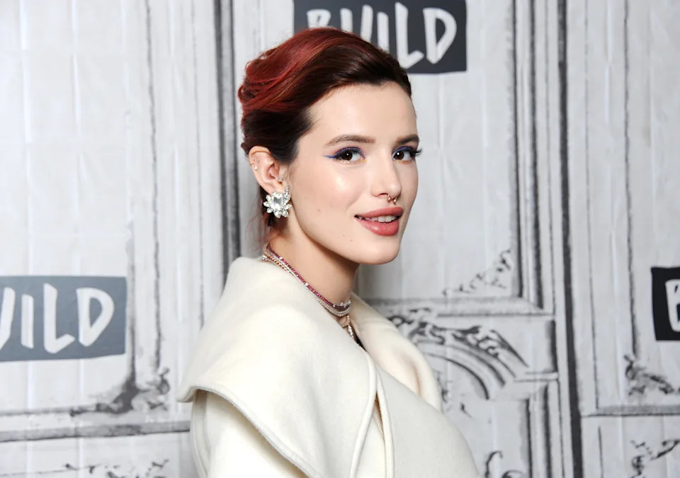Bella Thorne is wearing a white jacket and has her hair pinned up