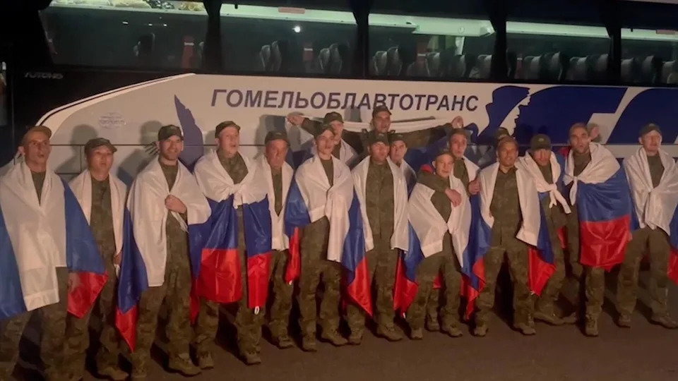 A screen grab taken from a video shows Russian military personnel being seen with national flags draped over their shoulders