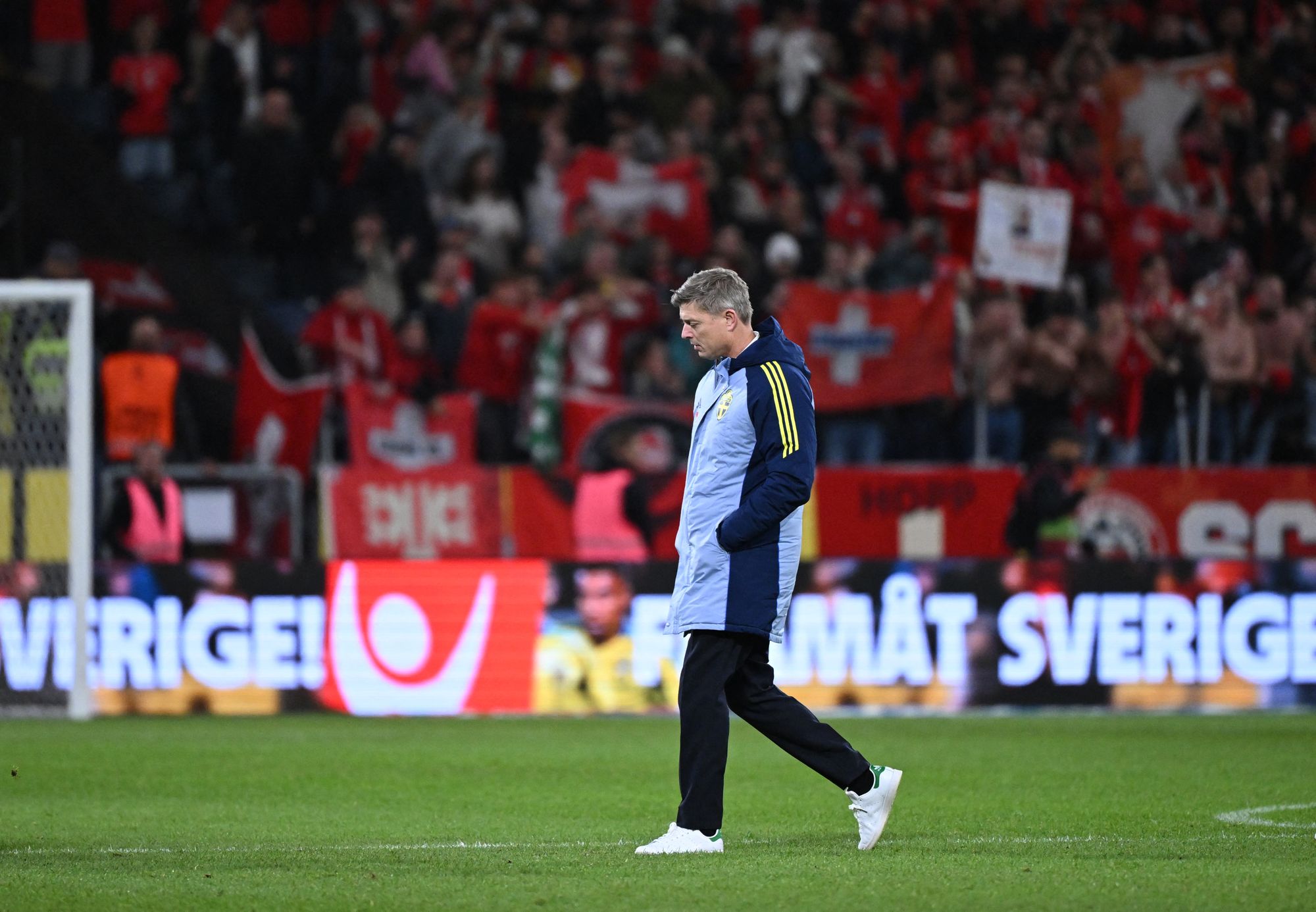 Jon Dahl Tomasson walks off the pitch after defeat by Switzerland