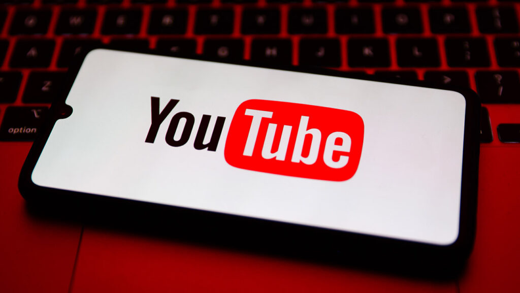 YouTube logo is displayed on a mobile phone screen