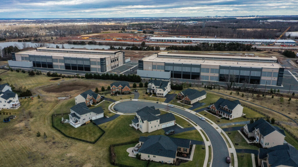 Amazon data centers loom over houses at the edge of a neighborhood in Loudoun County, Va. Credit: Jahi Chikwendiu/The Washington Post via Getty Images