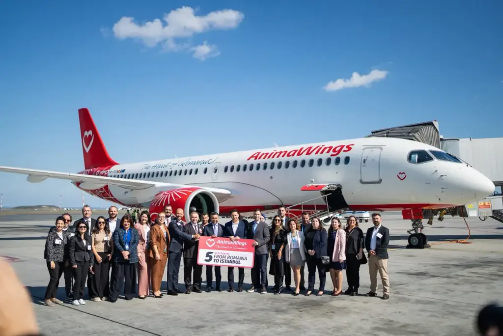 AnimaWings Begins Flights to Istanbul Airport AnimaWings airline team celebrates the launch of new flights from Romania to Istanbul at the airport beside an aircraft.