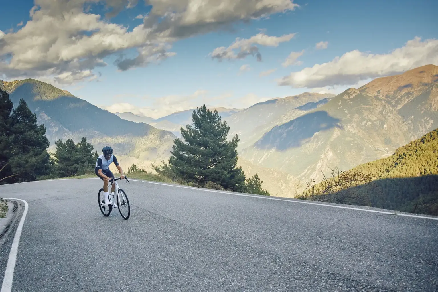 man riding up mountain road with nice view behind