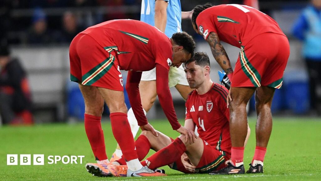 Ben Davies shows his distress at being injured as team-mates gather round