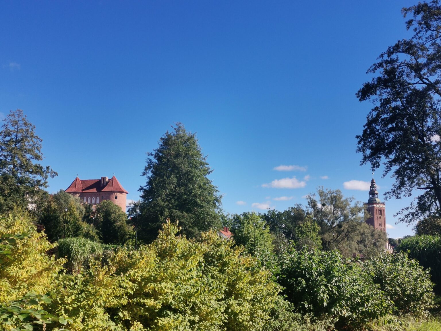Gothic church and High Gate of Lidzbark Warmiński, as seen from the park