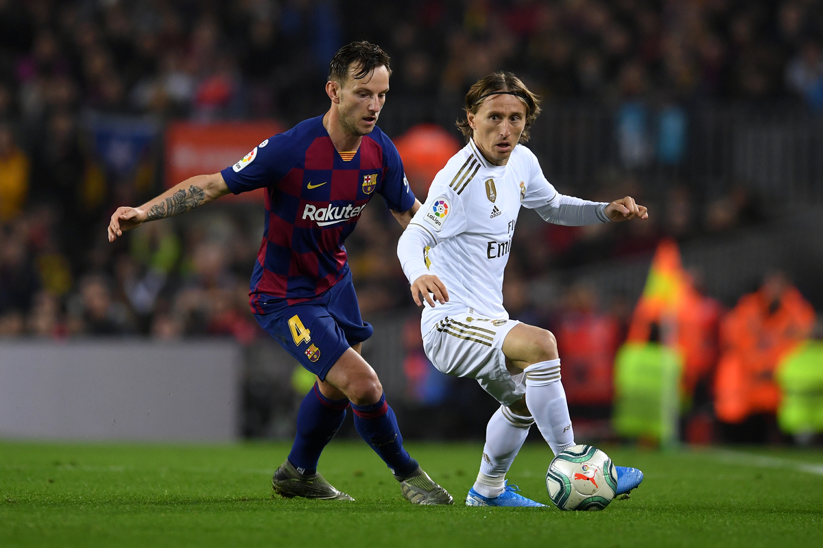 BARCELONA, SPAIN - DECEMBER 18:  Luka Modric of Real Madrid holds off Ivan Rakitic of Barcelona during the Liga match between FC Barcelona and Real Madrid CF at Camp Nou on December 18, 2019 in Barcelona, Spain. (Photo by Alex Caparros/Getty Images)