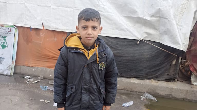 Musa Abusaileek outside a school building where the family first sought shelter in the early weeks of the war.