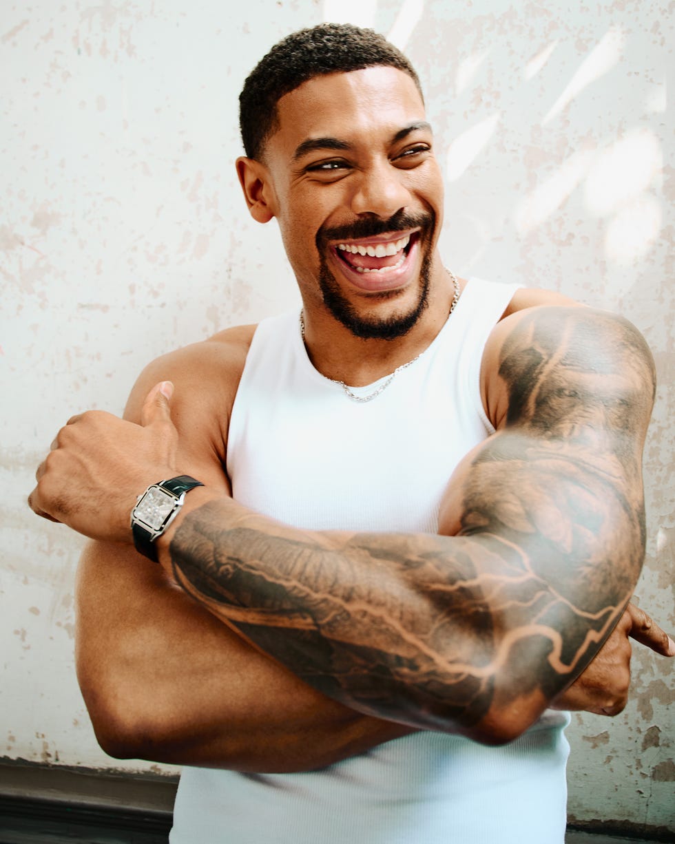 aaron pierre. tank by uniqlo\, chain and watch by cartier\, jeans by levi’s.