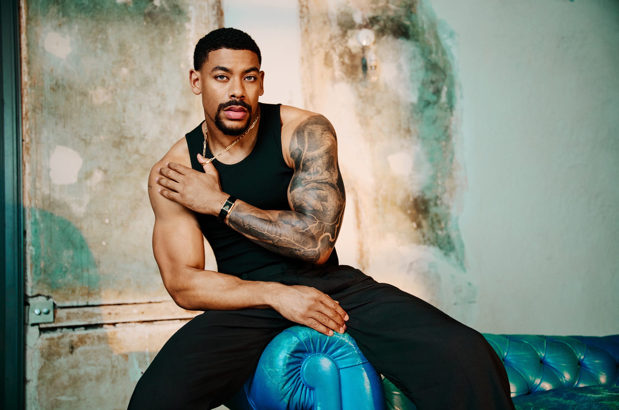 aaron pierre. tank by uniqlo\, trousers by cos\, shoes by boss\, watch by cartier.