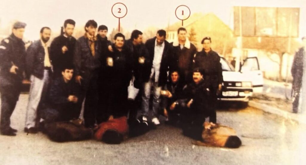 Armed Serbs in civilian clothes, together with Serbian policemen, posing in front of three executed Albanian civilians in Fush Kosovë. Among them are Balevic (1) and Gojkovic (2), both of whom also participated in numerous crimes in Pejë.