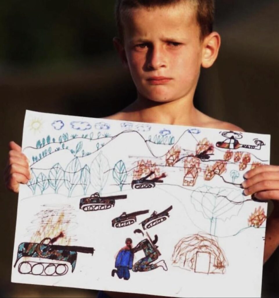 Albanian Child shows drawings of horrific things he saw in Kosovo at the Mebrosteno (Ilirida) refugee camp on May 29, 1999 | Photo by Joel Saget /Afp |