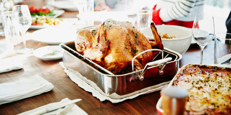 Turkey in roasting pan on table for holiday meal.