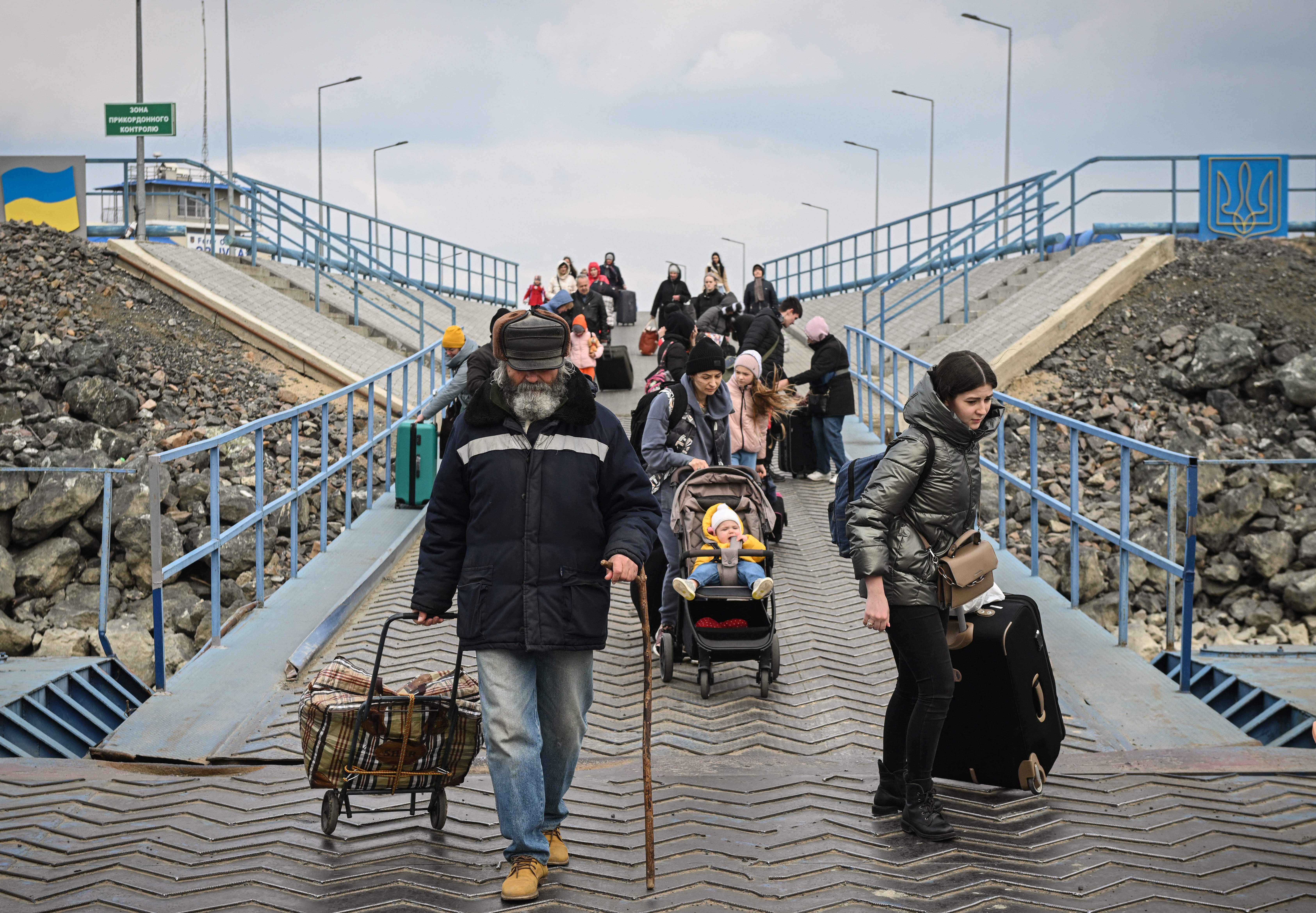 Ukrainian refugees, including children and elderly, board a ferry across the Danube river.