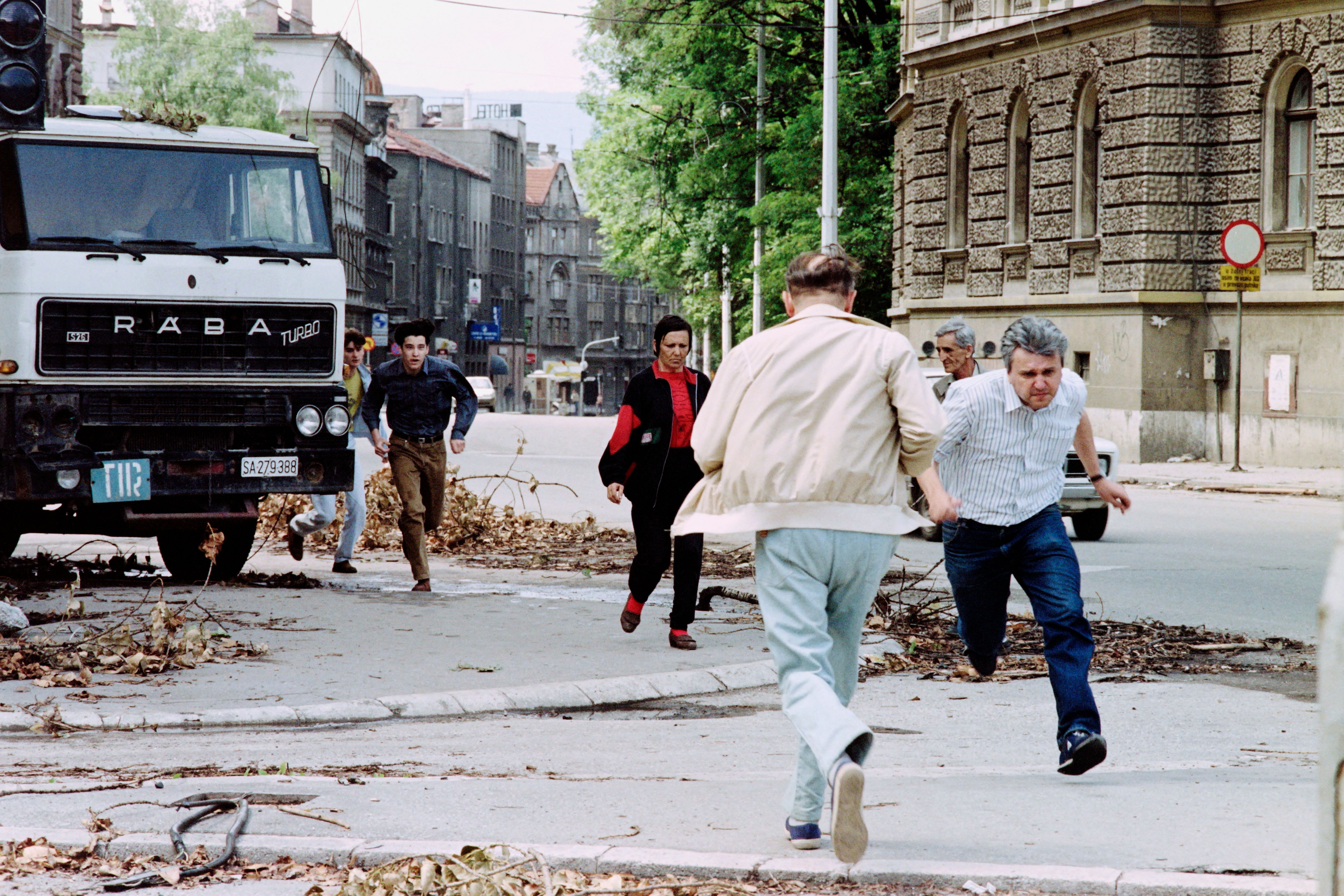 Civilians running for shelter on a street in Sarajevo.