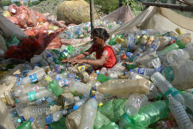 A woman collects plastic bottle for recycling at a dumpsite in Kolkata. (File Photo)