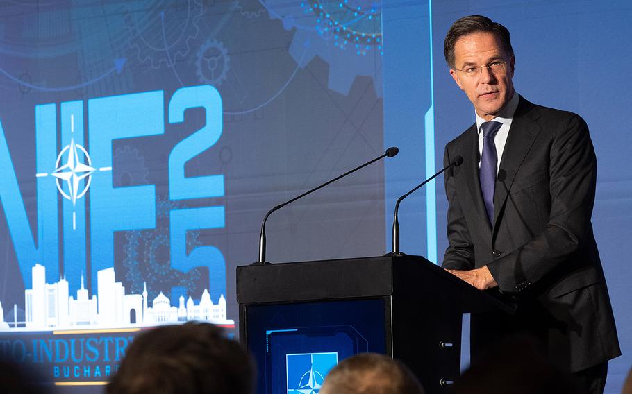 Mark Rutte stands behind a podium in a suit.