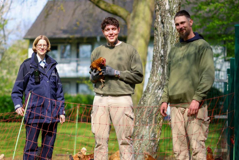 Officer Anika Schäfer, (left to right) pictured here with Ryan and Manuel, is responsible for the prison's chicken project. The inmates take care of young chickens that would otherwise end up at the slaughterhouse. Christoph Reichwein/dpa