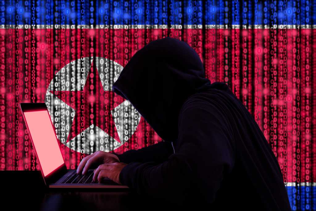 North Korean hackers exploit Google’s safety tools for remote wipe Hacker in a dark hoody sitting in front of a notebook with digital north korean flag and binary streams background cybersecurity concept