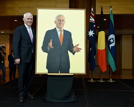 Former Australian Prime Minister Malcolm Turnbull stands next to his official portrait at Parliament House.