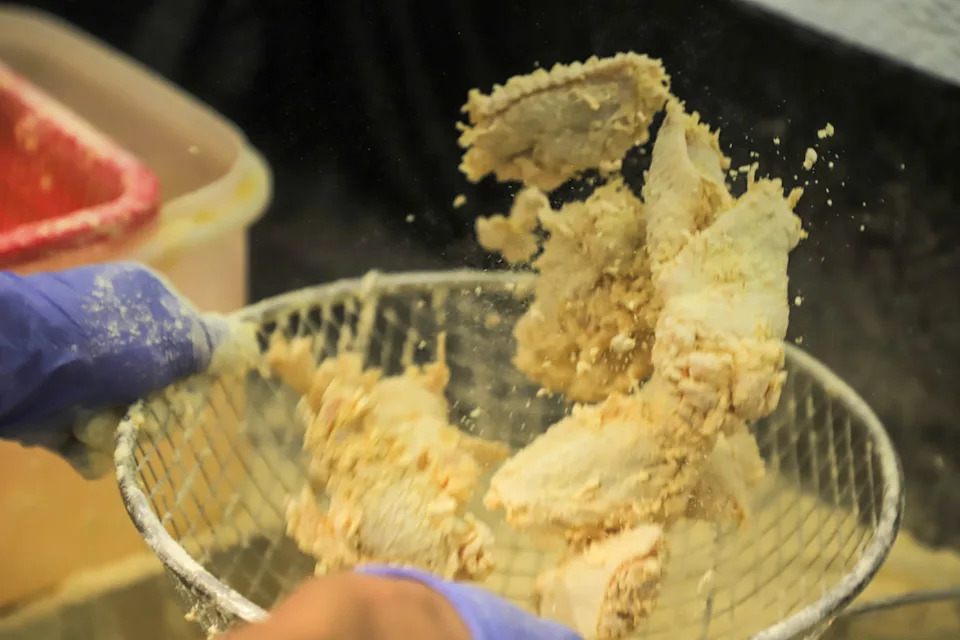 Daniel Lee, owner 92 Chicken, flips chicken wings as he tosses them in the breading before deep frying them on Tuesday, October 7, 2025 at his restaurant in Pooler Ga..