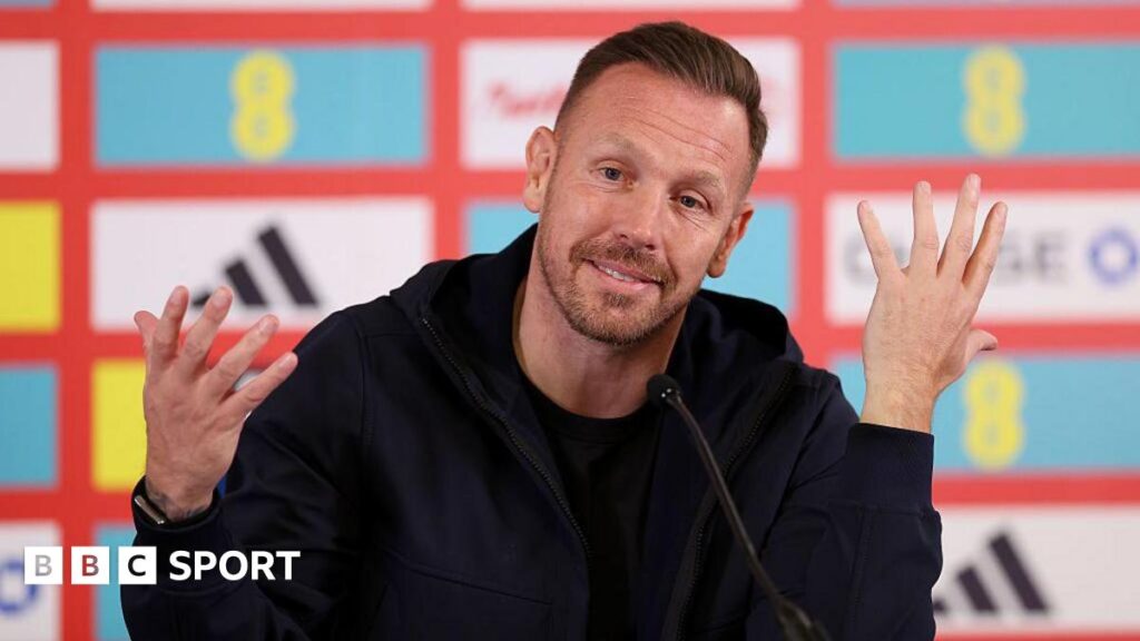 Craig Bellamy wears a dark jacket and top