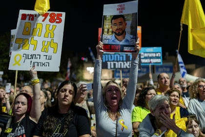 Protesters at Hostage Square holding the sign of Ran Gvili, whose body is still held in Gaza.