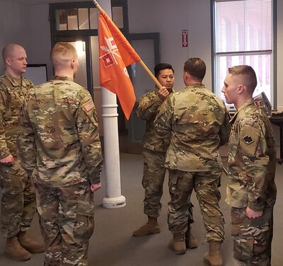 Minas (center, holding flag) performing the Change of Command military tradition. 