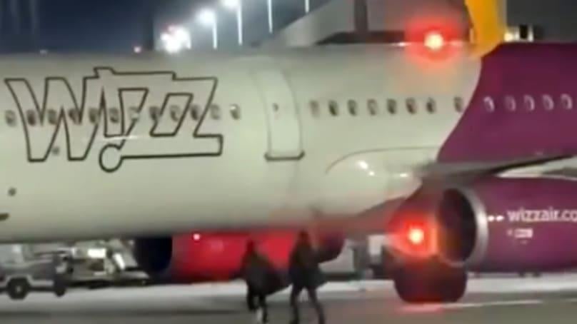 Two Romanians run on the runway of Cologne airport to catch the plane they lost.