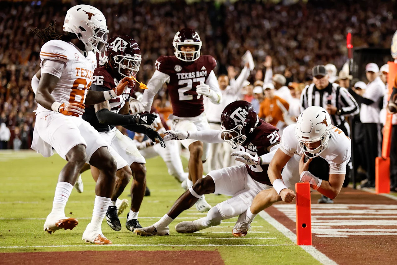 COLLEGE STATION, TEXAS - NOVEMBER 30: Arch Manning #16 of the Texas Longhorns dives into the end zone for a touchdown against Dalton Brooks #25 of the Texas A&M Aggies in the first half against the Texas A&M Aggies at Kyle Field on November 30, 2024 in College Station, Texas. (Photo by Tim Warner/Getty Images)