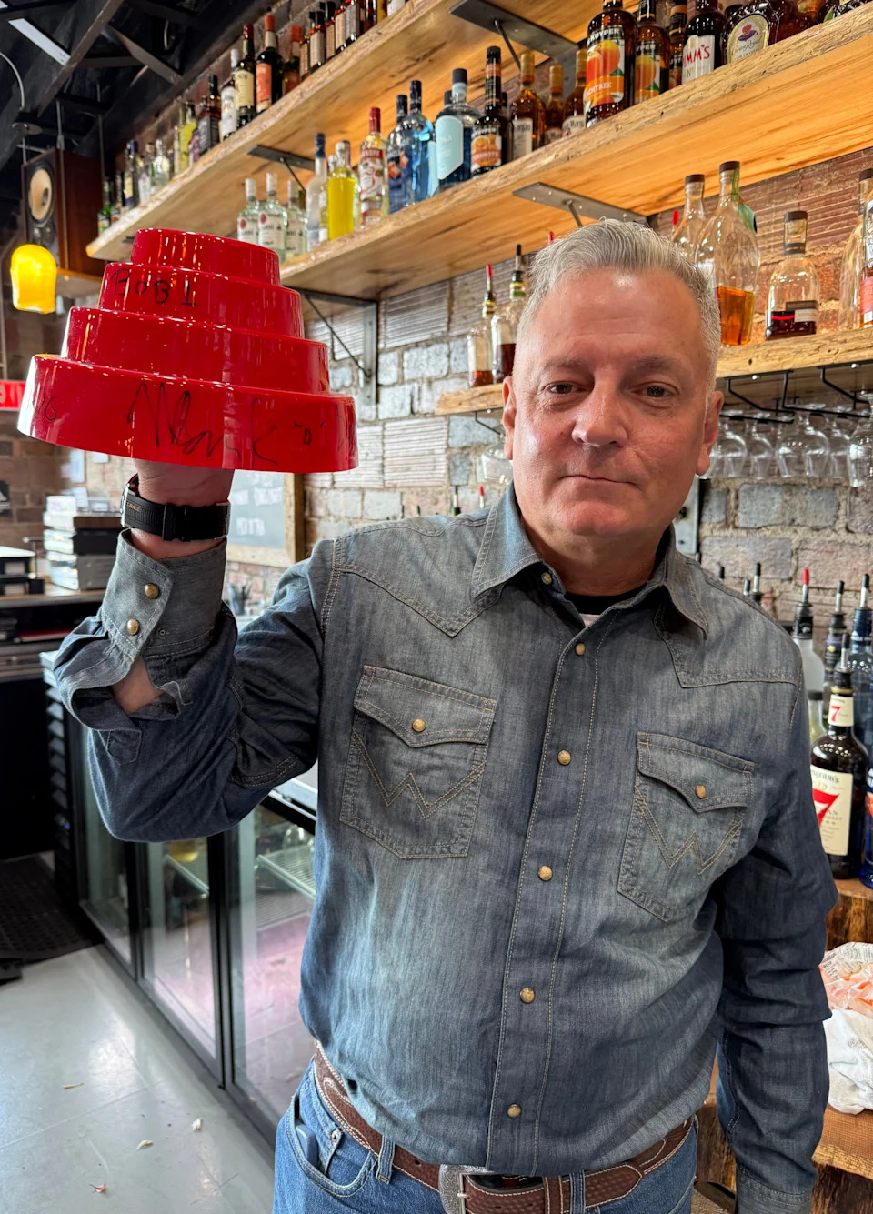 Don Whittingham, owner of The Delaware in New Philadelphia, displays a signed piece of memorabilia from the new wave band Devo. The live music venue features both local and touring bands and artists.