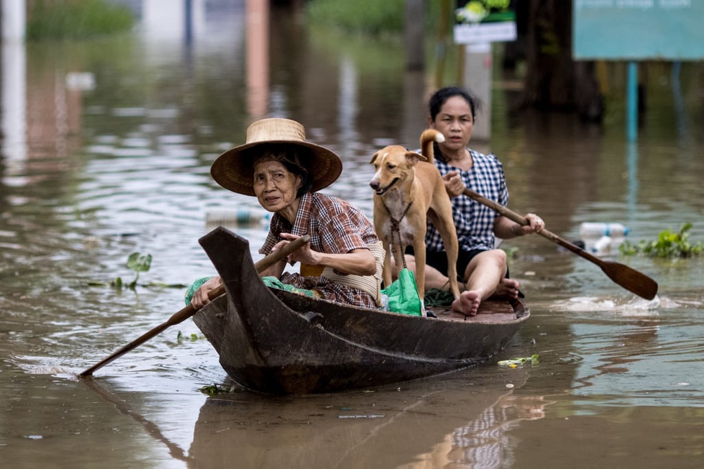 An elderly woman traverses floodwaters in an Ayutthaya neighbourhood after heavy rains. Photo: AFP