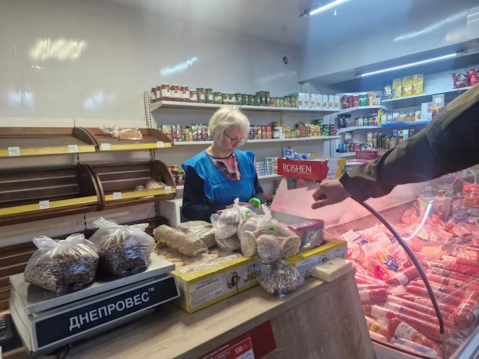 Viktoria Sergeeva, 45, recently fled to Dobropillia, Ukraine, from Pokrovsk after a bombing there killed her elderly mother and father. She's pictured at the grocery story she now runs on Oct. 30, 2025.