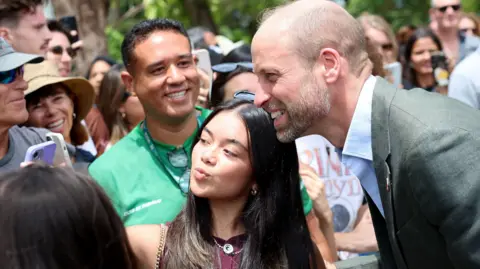 PA Media Prince William and a woman taking a selfie