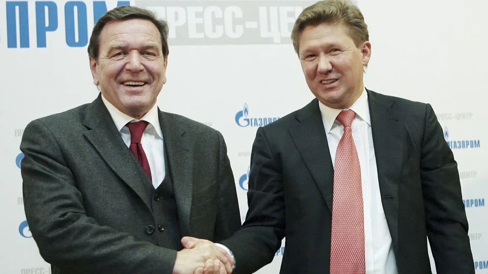 Former German Chancellor Gerhard Schroeder and Gazprom's Chief Executive Alexei Miller (R) shake hands during a news conference for the Russian natural gas monopoly Gazprom on March 30, 2006 at the headquarters in Moscow, Russia. - Evgeny Malyshev/Pressphotos/Getty Images