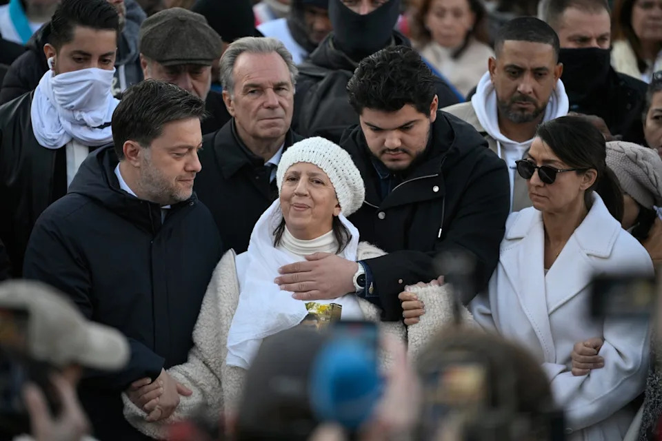 Amine Kessaci, center, and his mother attend a gathering in homage to his brother Mehdi Kessaci at the roundabout where he was murdered, and to protest against drug trafficking, in Marseille, southern France, Saturday, Nov. 22, 2025. (AP Photo/Philippe Magoni) (Copyright 2025 The Associated Press. All rights reserved)