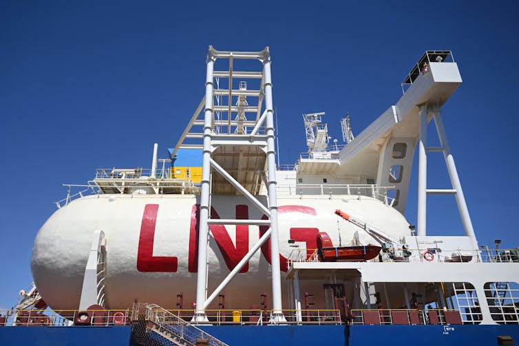 A large gas container emblazoned with the letters 'LNG' on the deck of a ship.