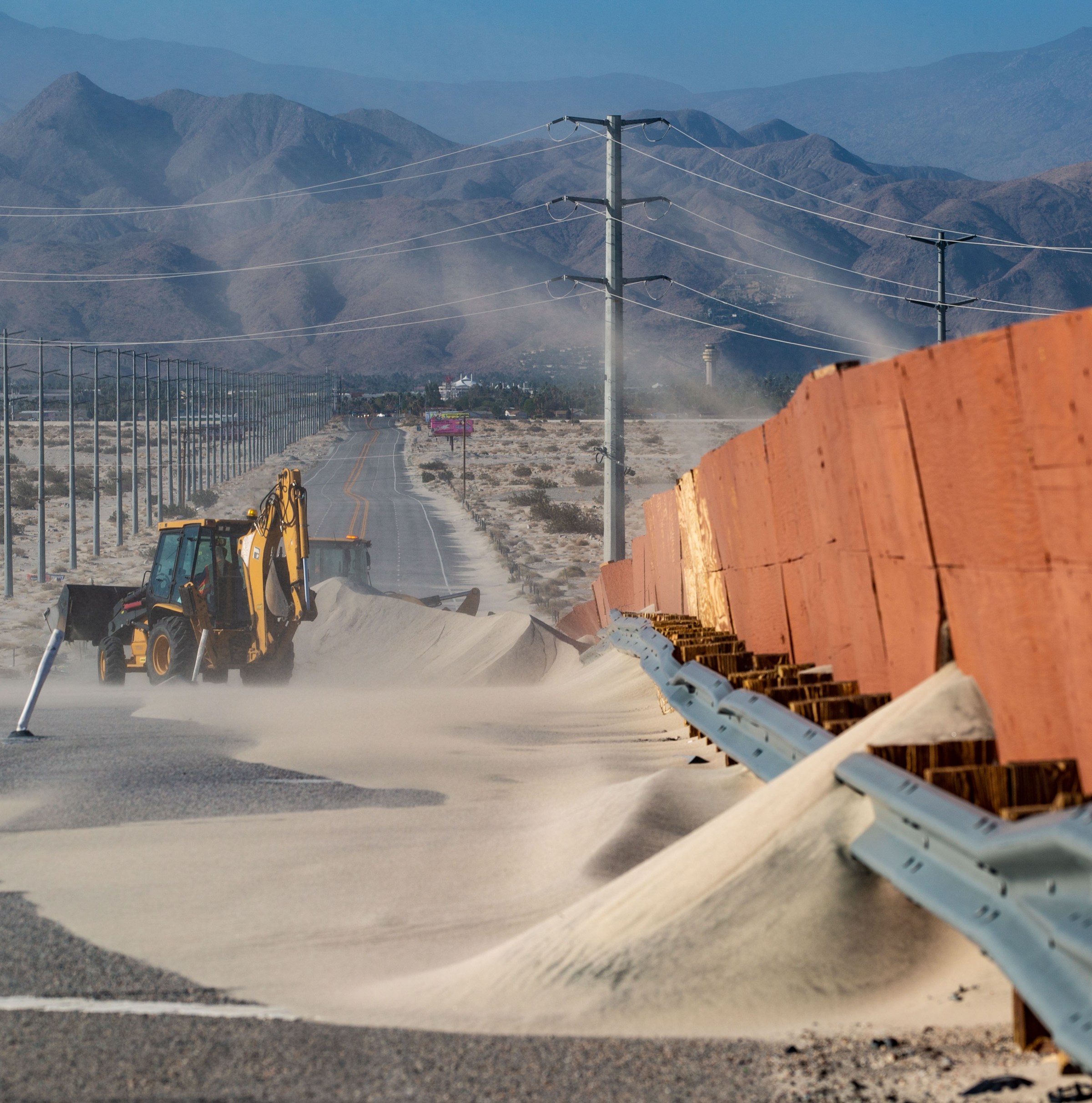 Construction equipment sits in a pile of sand