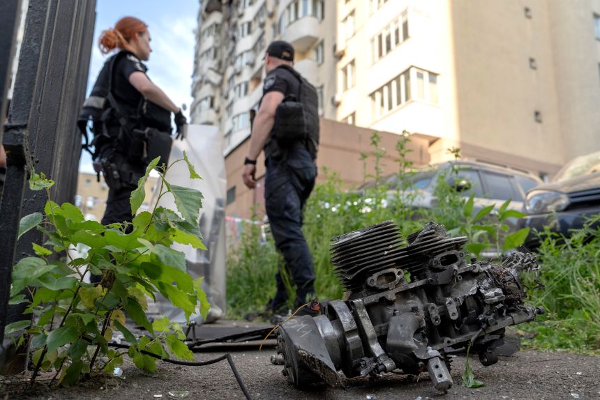 Police officers collect drone missile parts at the site of a Russian overnight attack in Kyiv, Ukraine, on June 6, 2025.