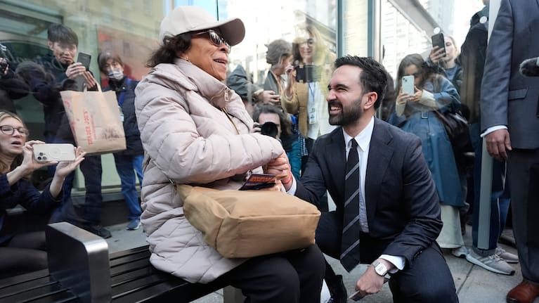 New York City mayoral candidate Zohran Mamdani talks with Rita Bellevue as she waits at a bus stop in New York, Monday, Oct. 27, 2025.