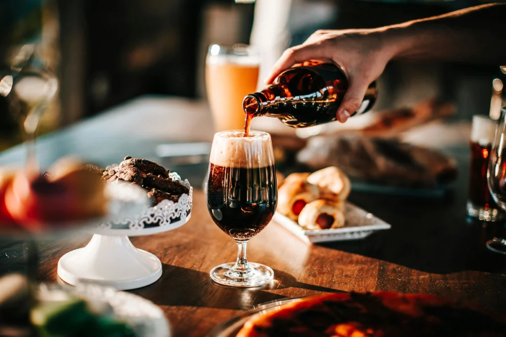 A person pouring alcohol in a wine glass