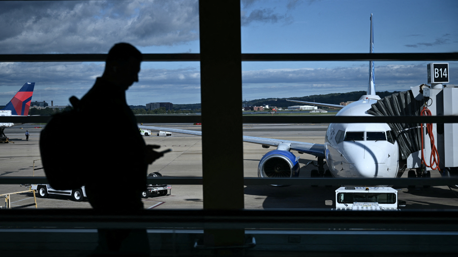 A man checks phone at Reagan National Airport amid the government shutdown