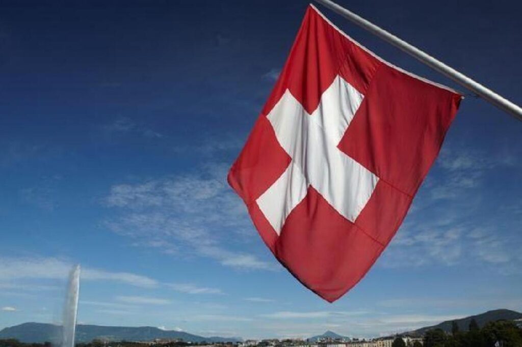 A Swiss national flag flies against the sky over Lake Geneva in Geneva, Switzerland. (AA Photo)