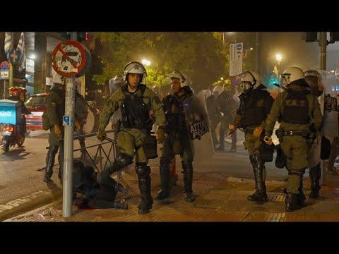 Matatzis kicks a helmeted protester on the ground in the face