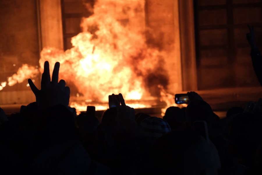 The situation escalates, a Molotov cocktail is thrown at the door.