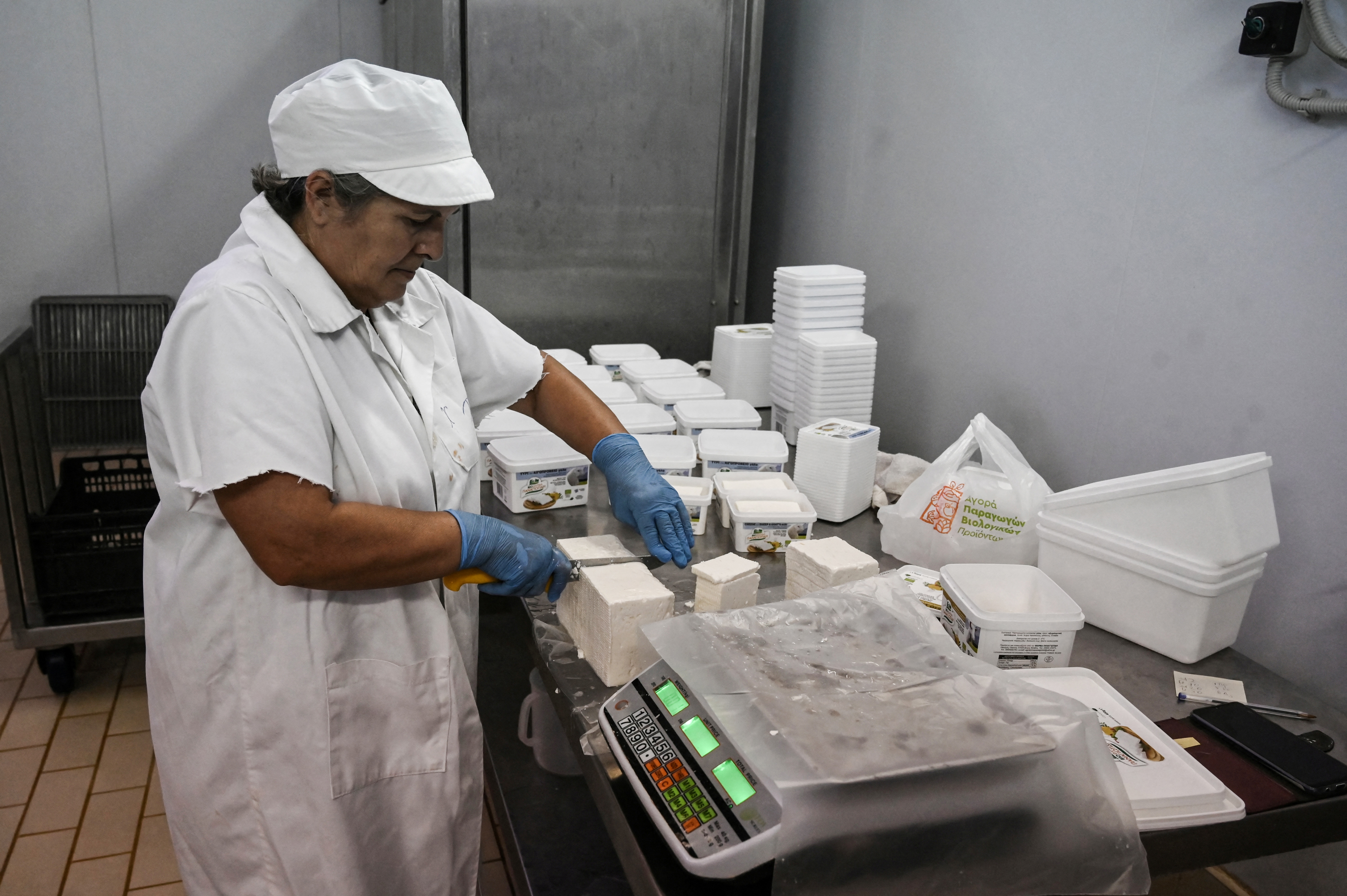 An employee cuts feta cheese in a farm near Thessaloniki.